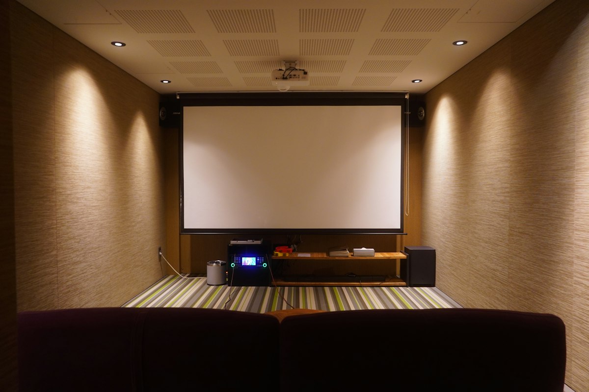Sistem home theater modern dengan speaker berkualitas tinggi dan proyektor 4K dalam ruang keluarga